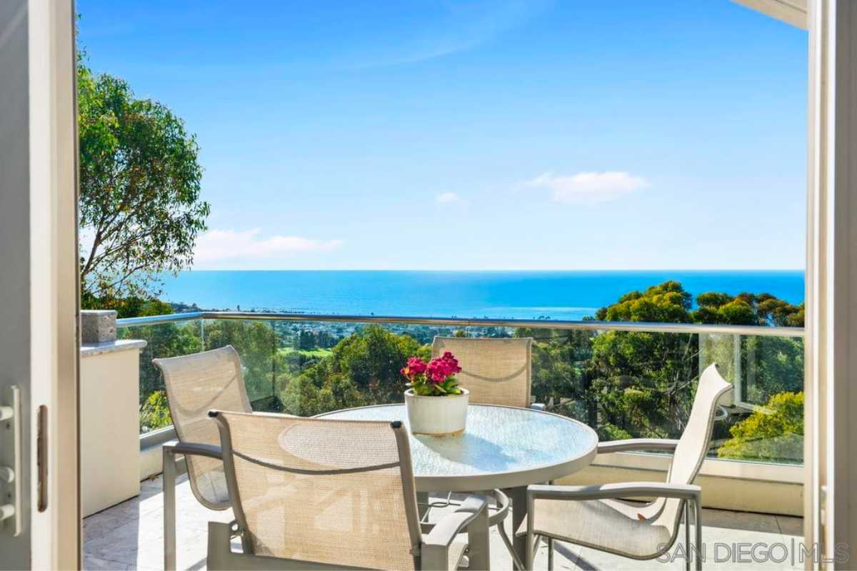 A balcony with a table and chairs.