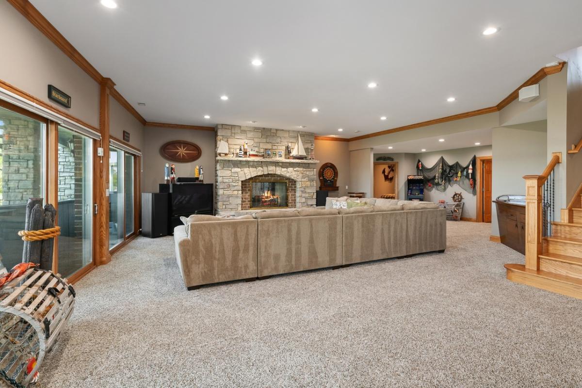 Family room with couches, carpet flooring and a fireplace.