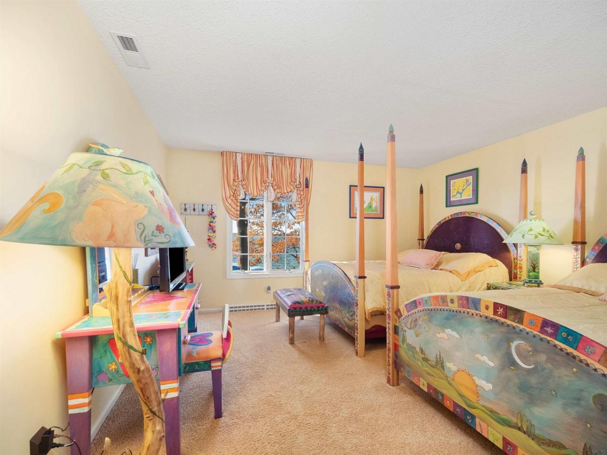 Bedroom with two beds, glass windows and carpet flooring.