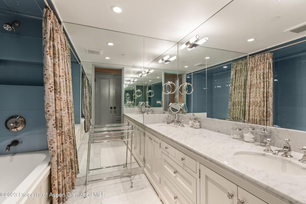 Bathroom with dual sinks, mirror and a soaking tub. 