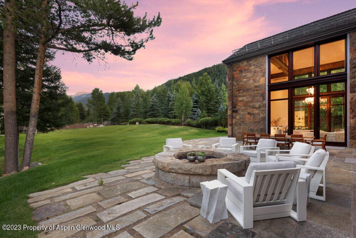 Patio with a fire pit and chairs.