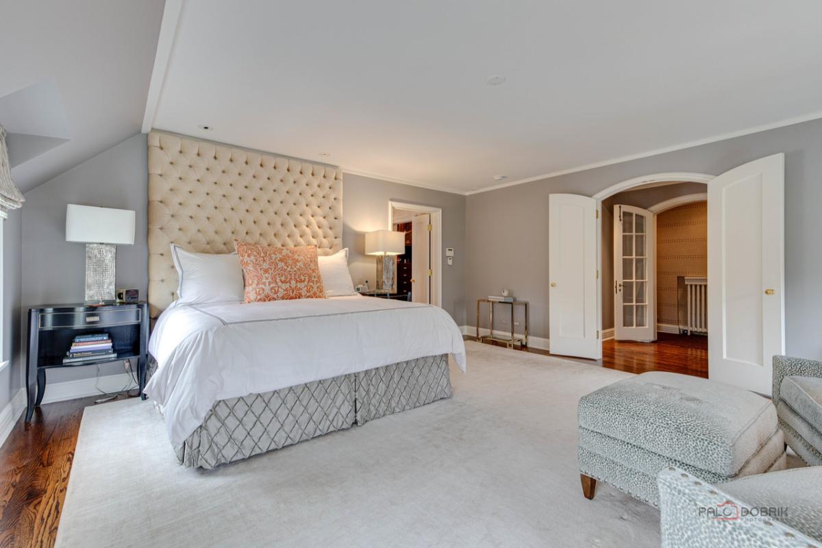 Bedroom with a large bed, wooden door and a large rug.