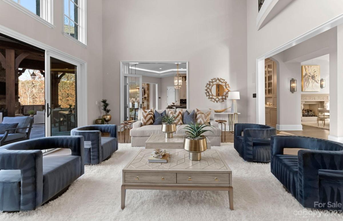 Living room with a couch, large rug and glass doors.