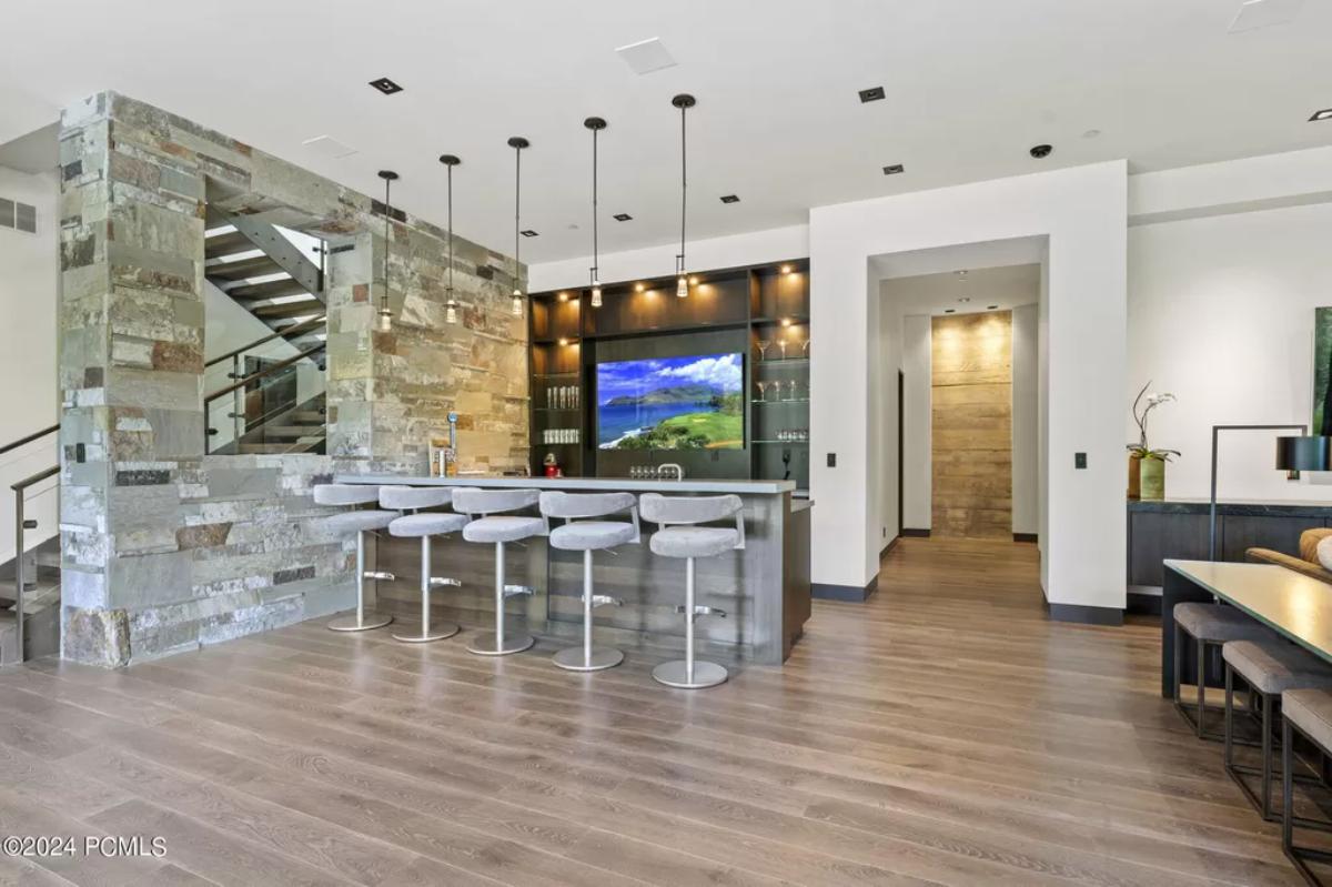 Bar with chairs, wooden floor and custom lights.