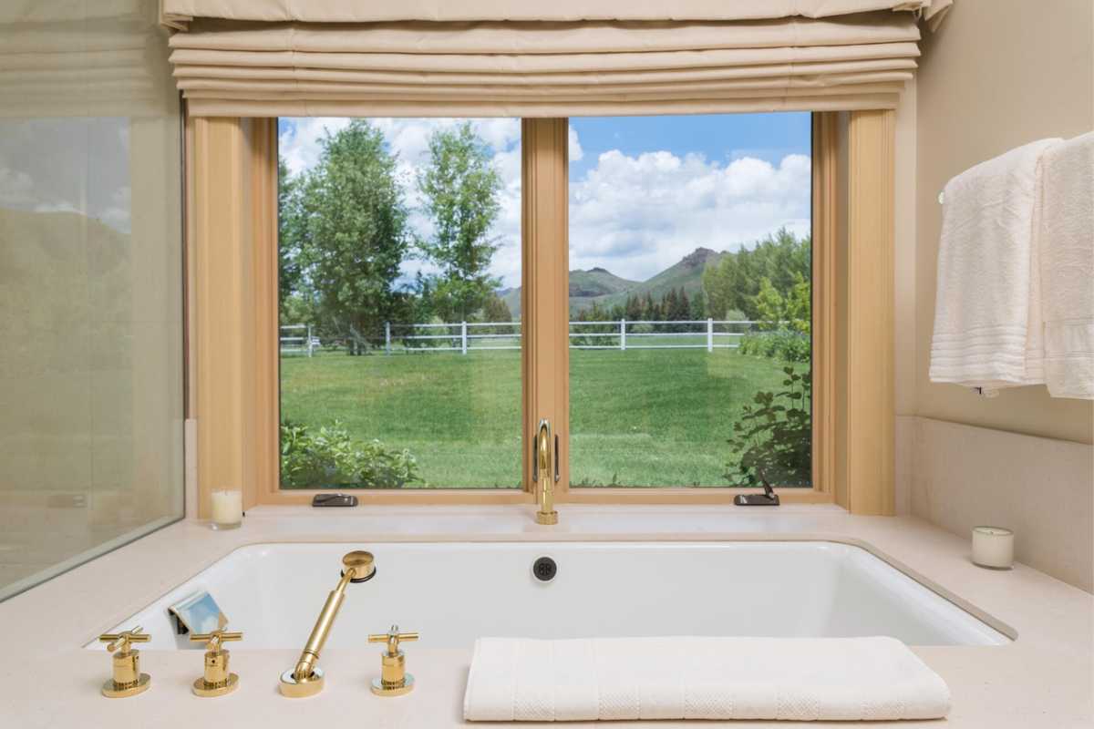 A bathroom with a bathtub, sink, and window.