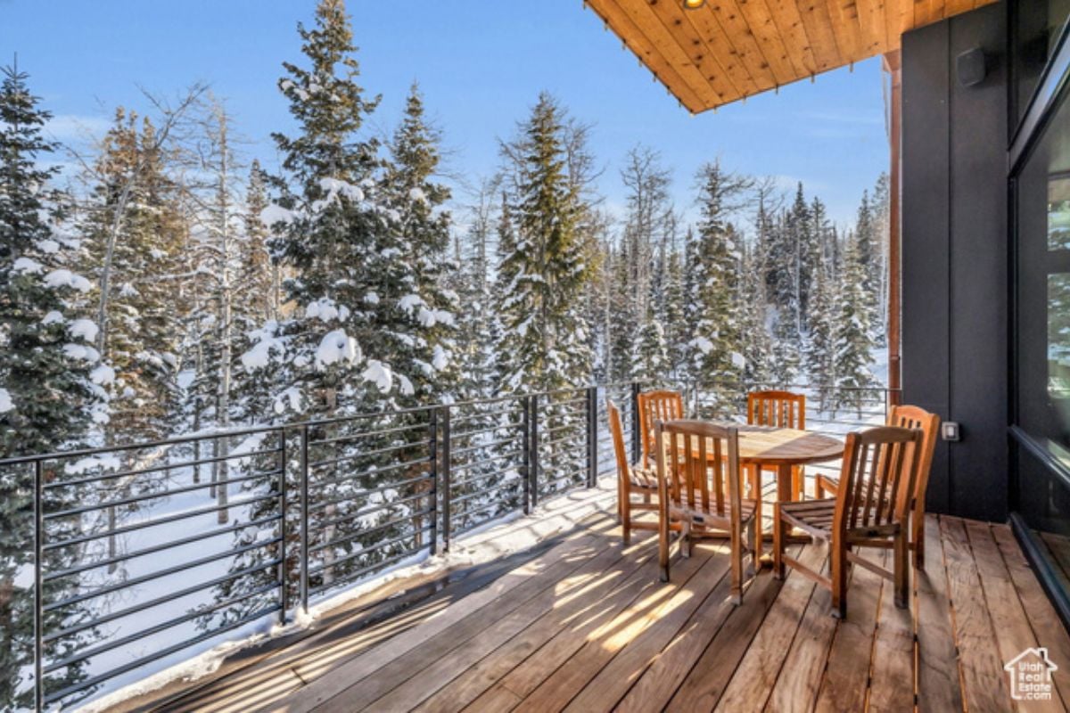 a wooden deck with table, chairs, and metal railings