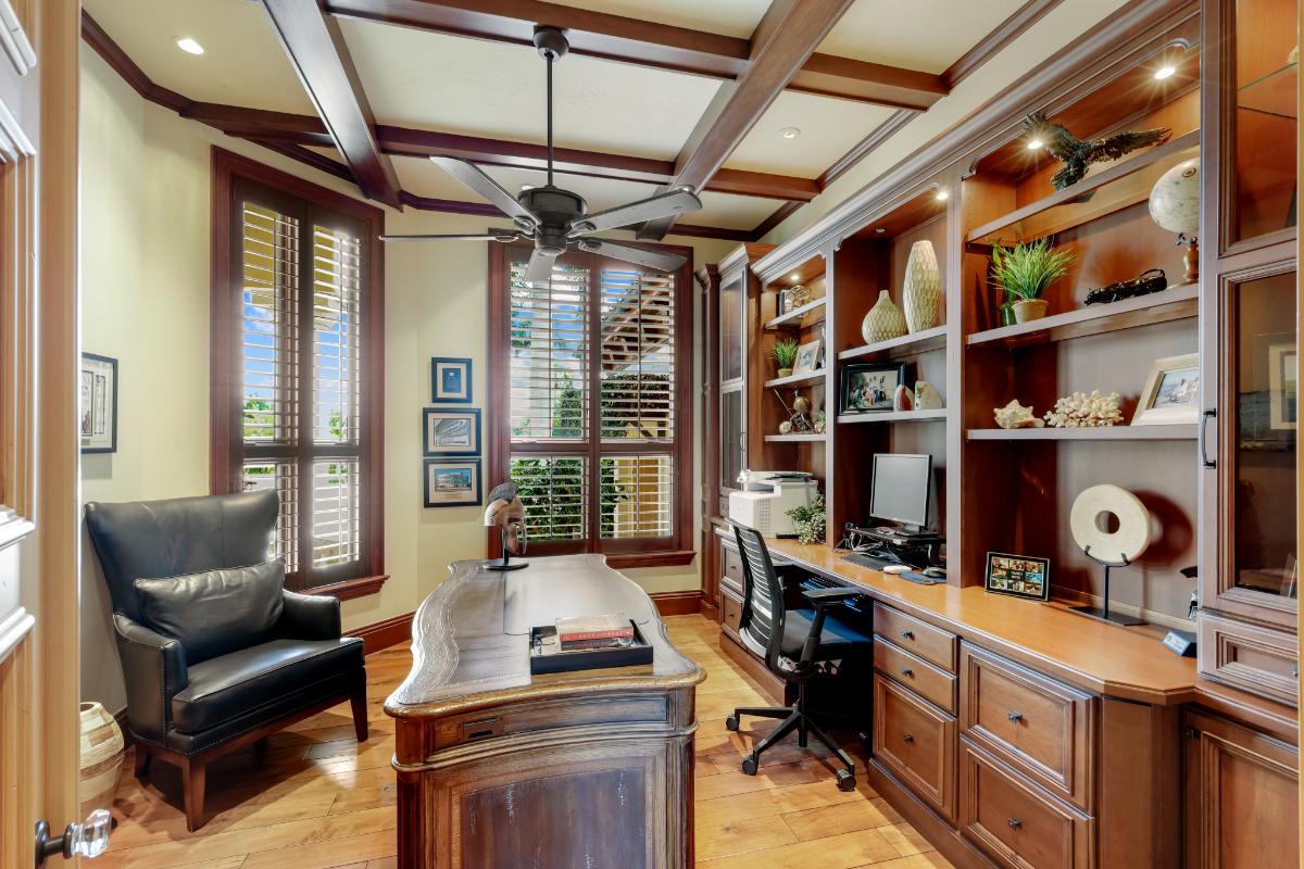 Home office with a desk, computer, chairs and custom lights.