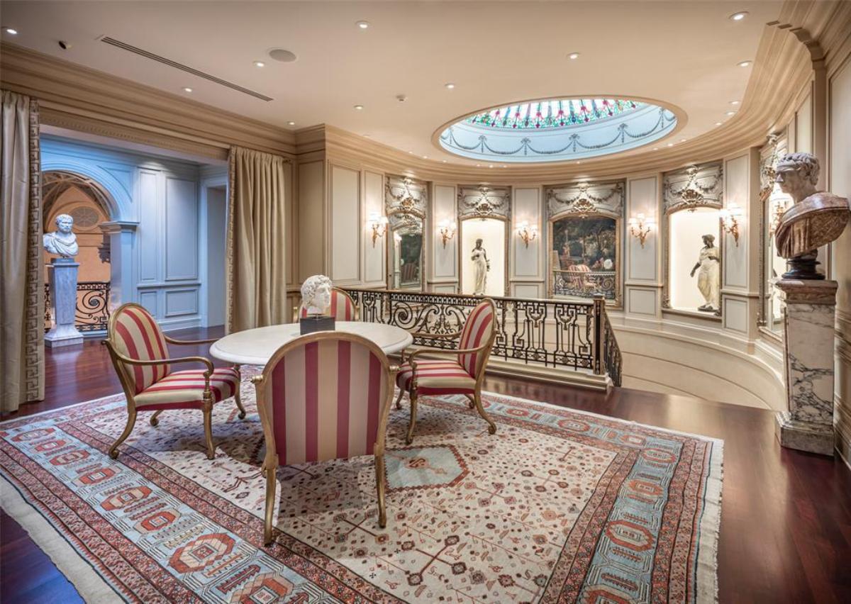 Landing with a skylight, large rug, table and chairs.