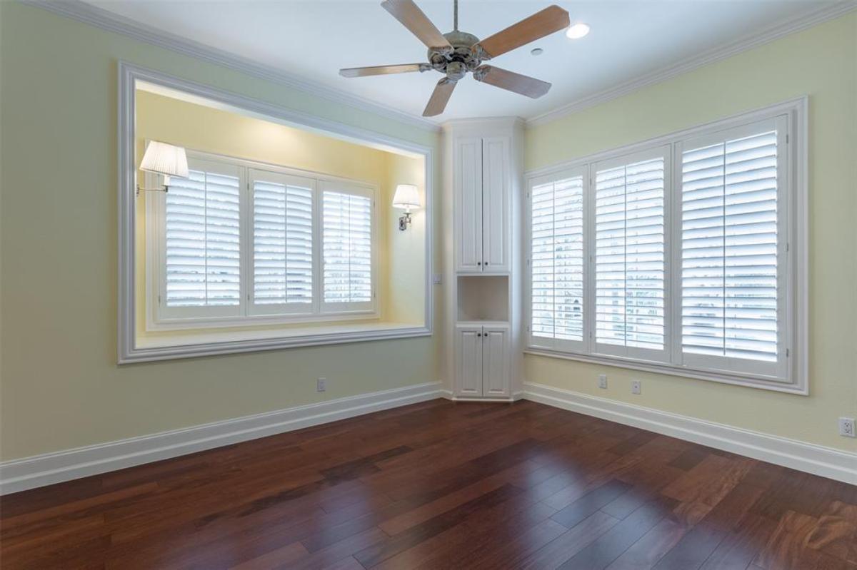 Bedroom with a ceiling fan and wood flooring.