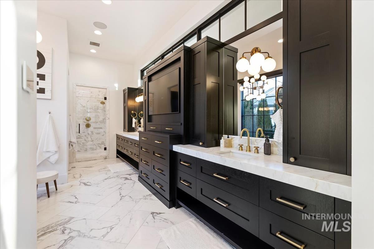 Bathroom with a sink, mirror and black cabinets.