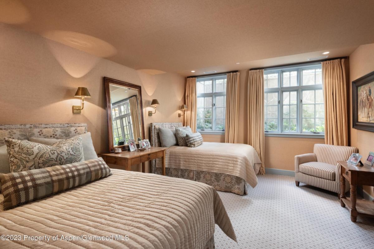 Bedroom with two beds and a chair.
