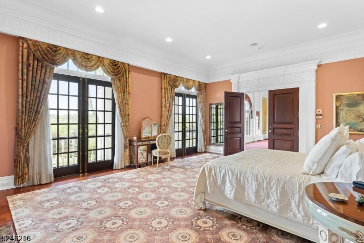 Bedroom with a large bed, custom lights and glass doors.