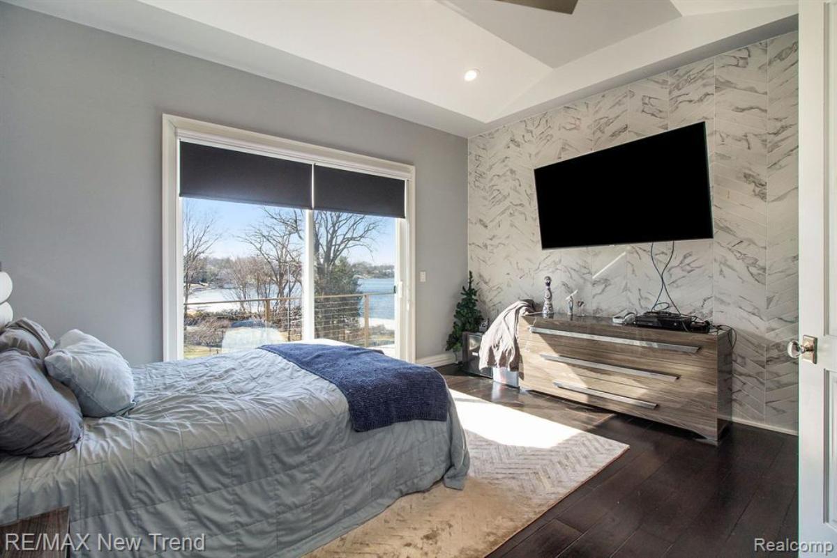 Bedroom with a large bed, TV and glass doors.