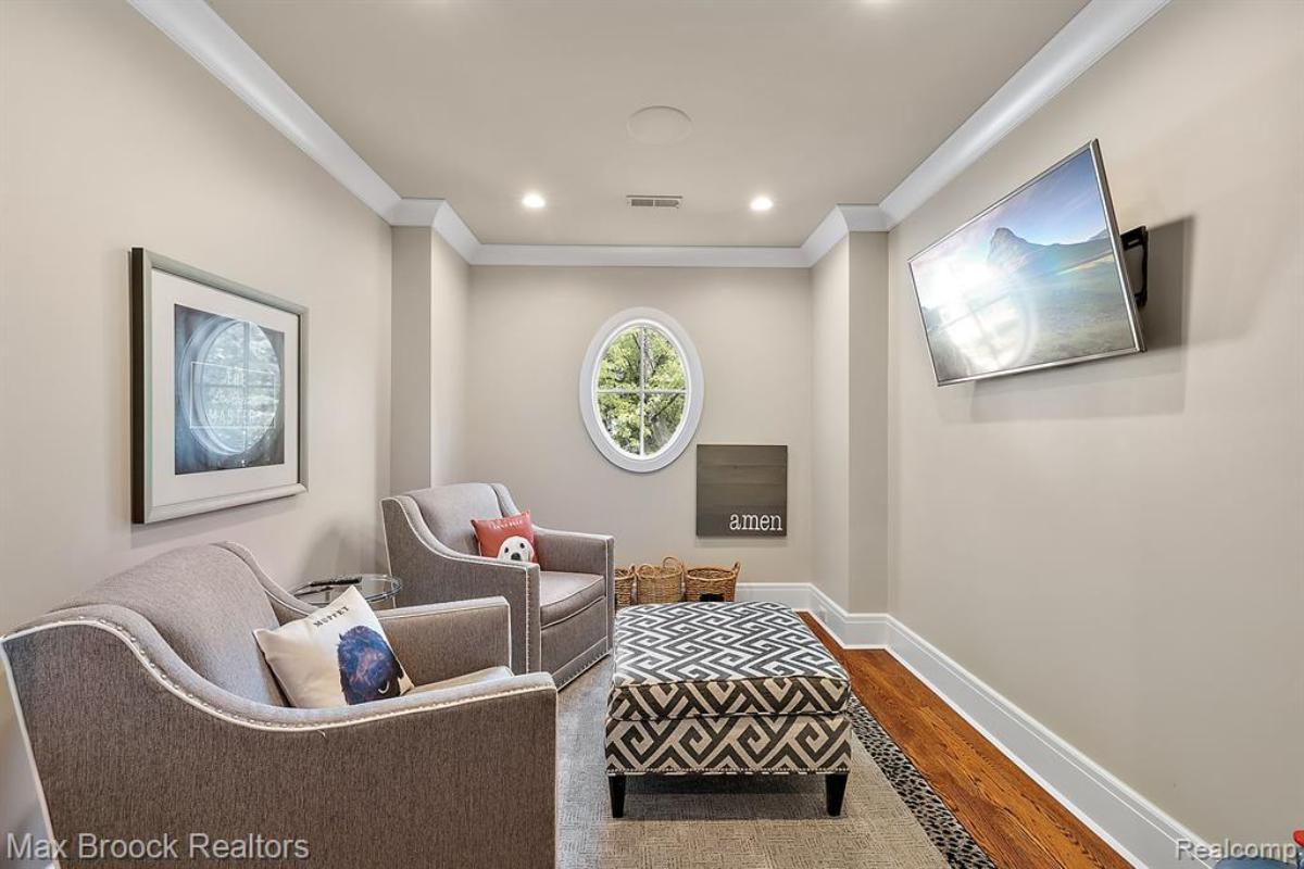 Sitting room with chairs, TV and a large rug. 