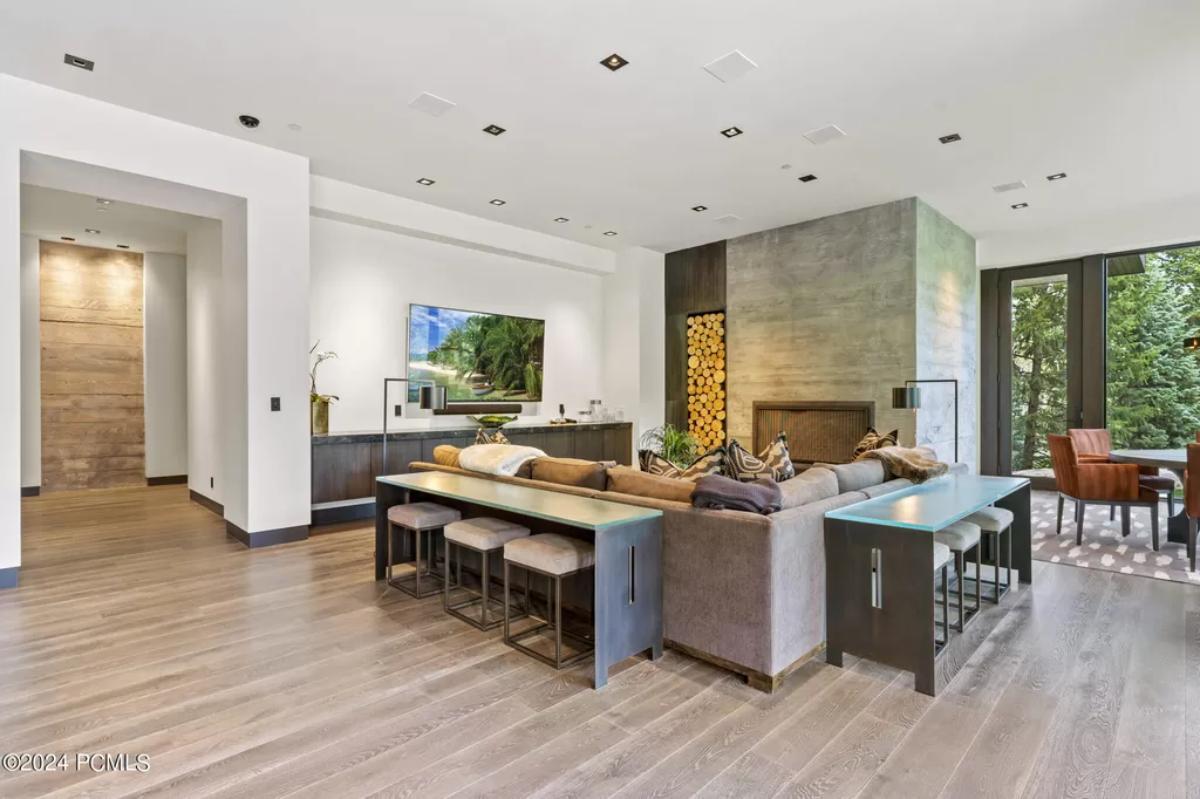 Living area with couches, TV and a wooden floor.