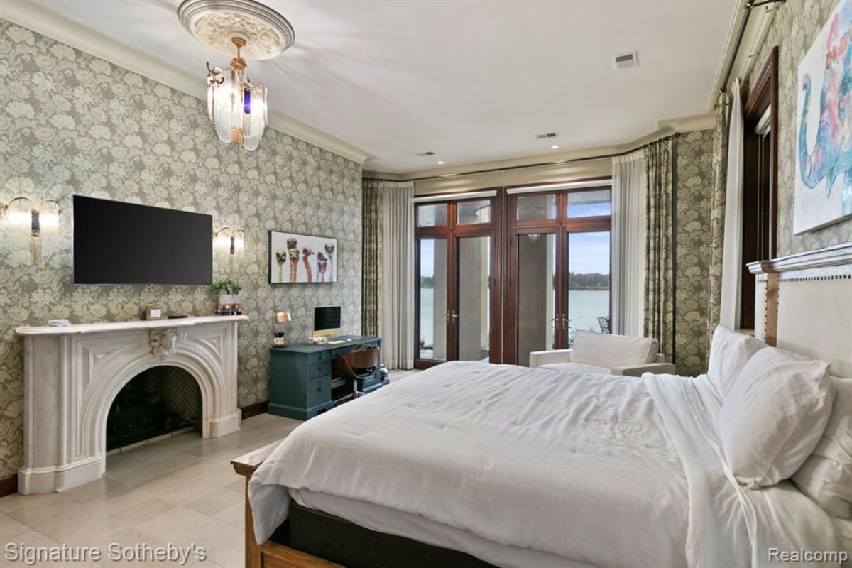 a bedroom with bed, fireplace, TV, windows and white ceiling