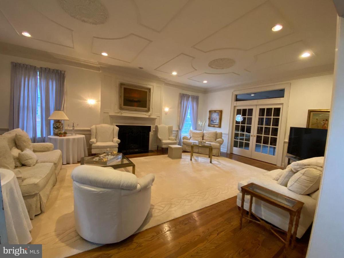 Living room with tables, chairs and a fireplace.