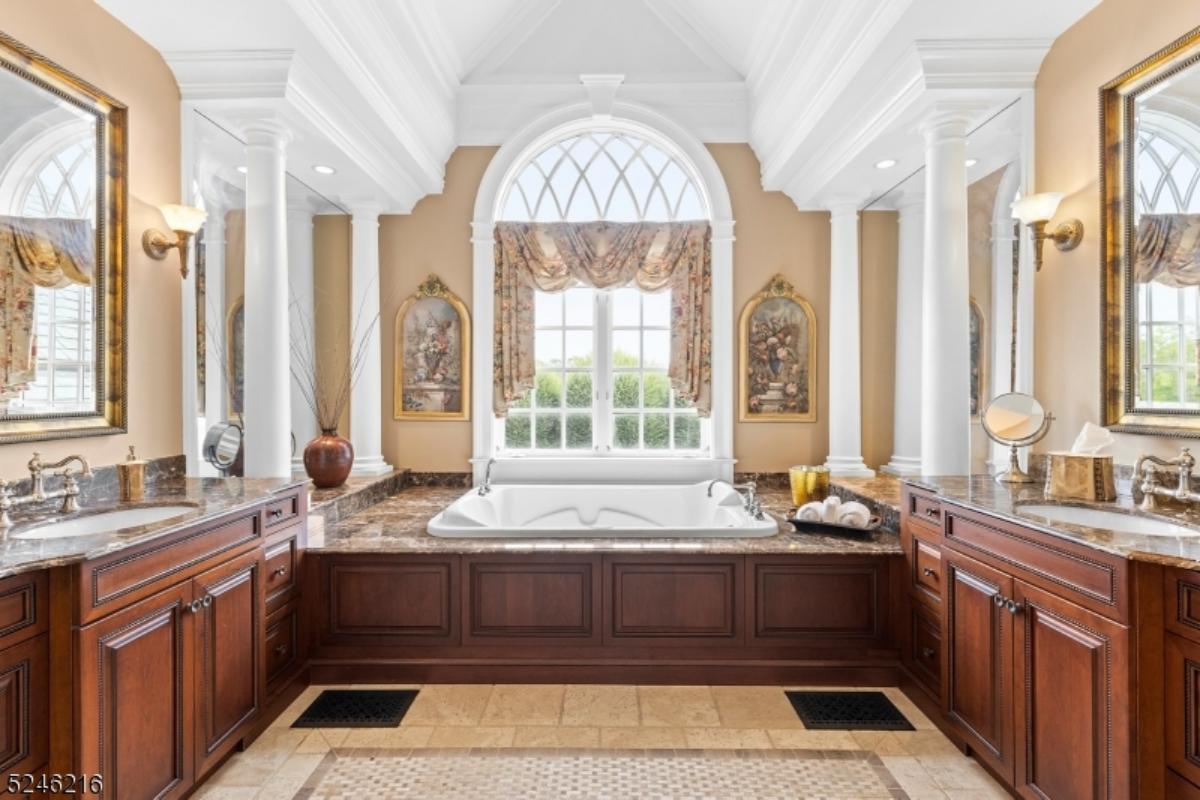 Bathroom with dual sinks, soaking tub and glass windows.