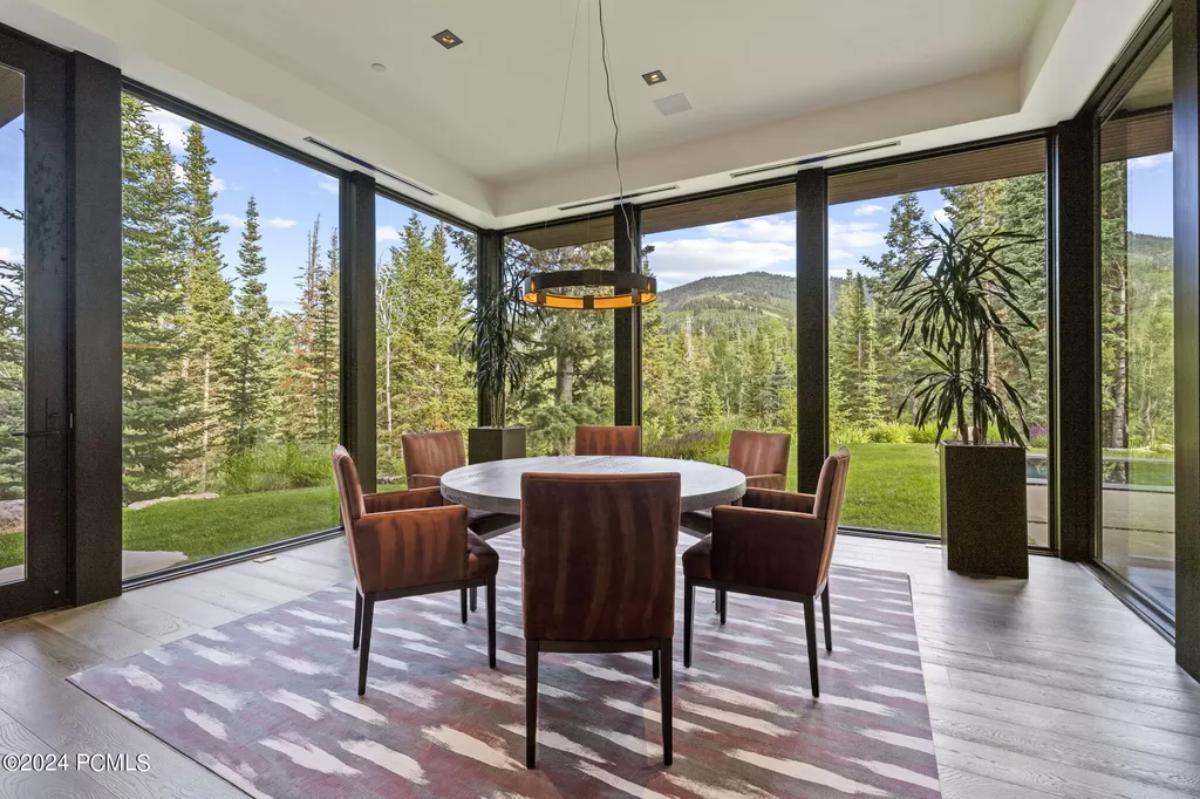 Dining room with a round table, chairs and glass walls.