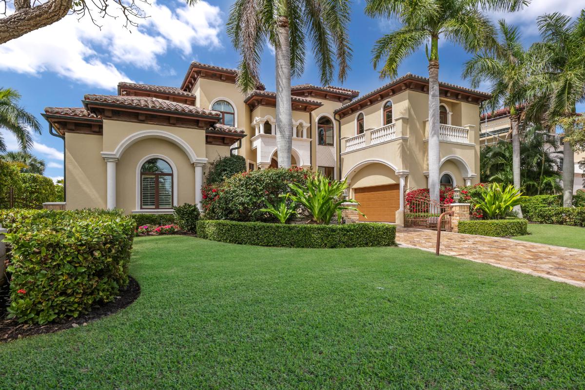 Front yard of the mansion with a large green lawn and a driveway.