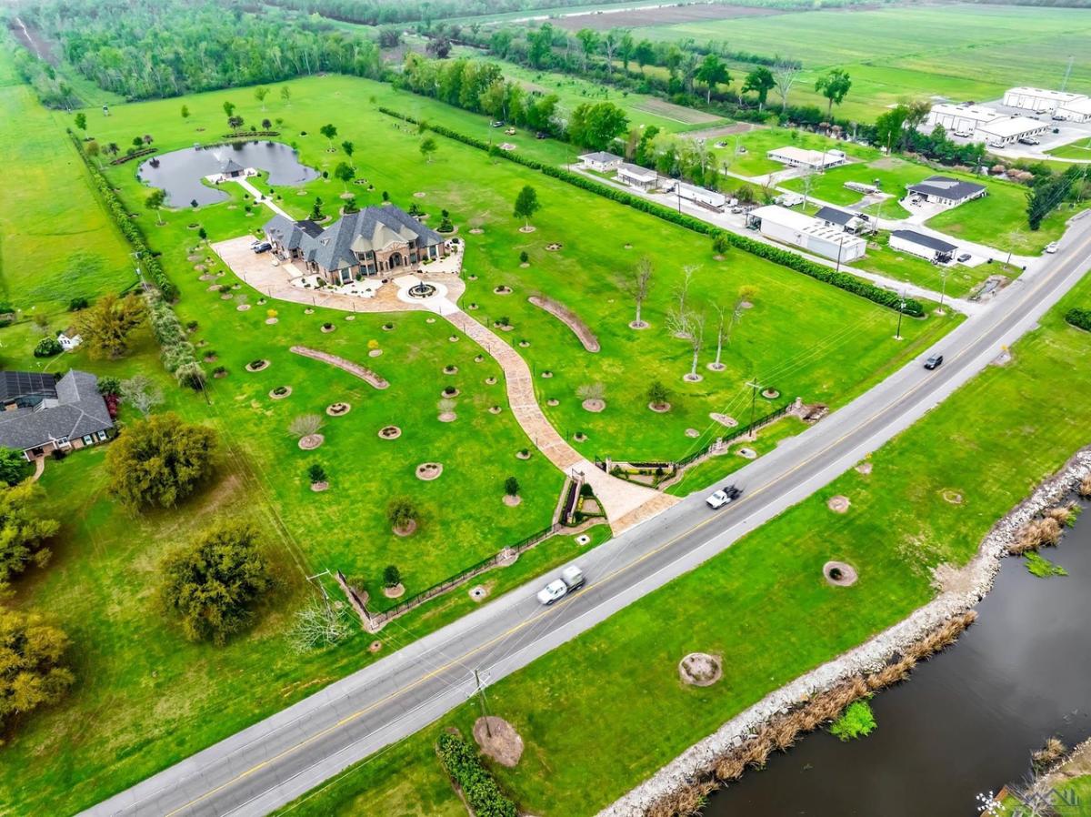 Aerial view of the property with a large green lawn.