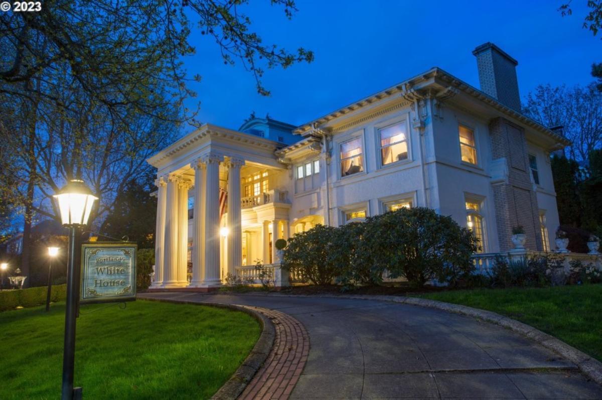 Front view of the mansion with a spacious driveway.