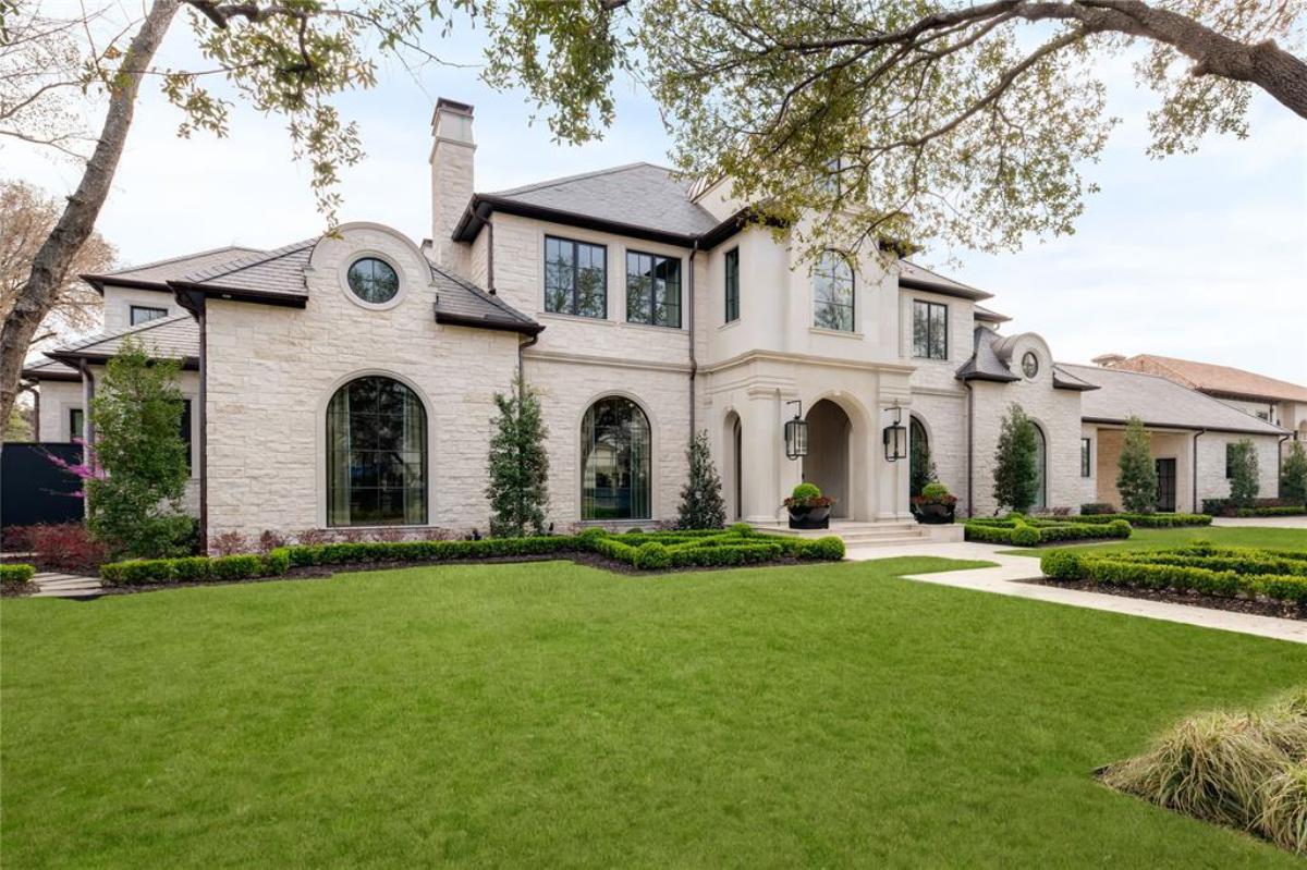 Front view of the mansion with large green lawn.