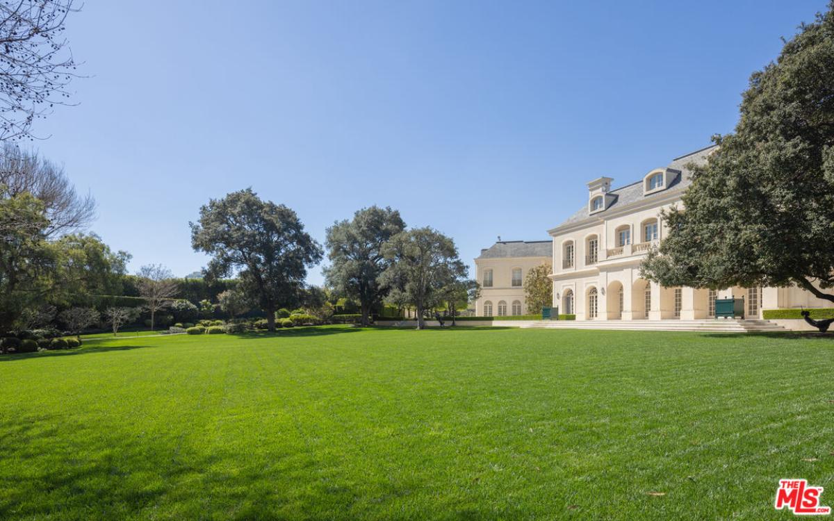Rear view of the property with a large green lawn.