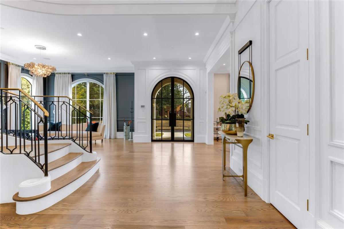 Foyer with a glass door, wooden floor and a staircase.