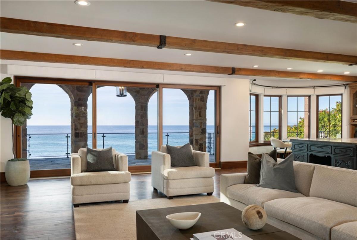 Living room with a couch, chairs, custom lights and glass doors.