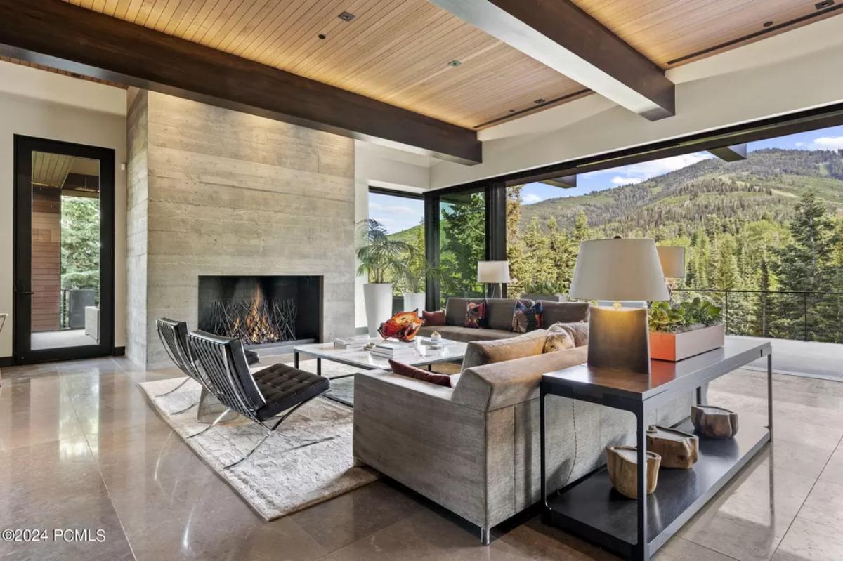 Living room with couches, chairs, fireplace and a large rug.