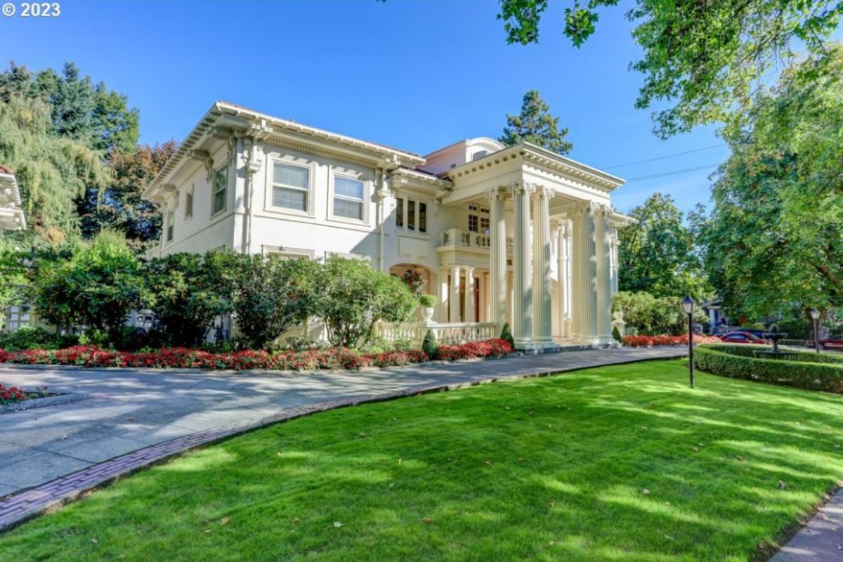 Front view of the mansion with a large lawn.