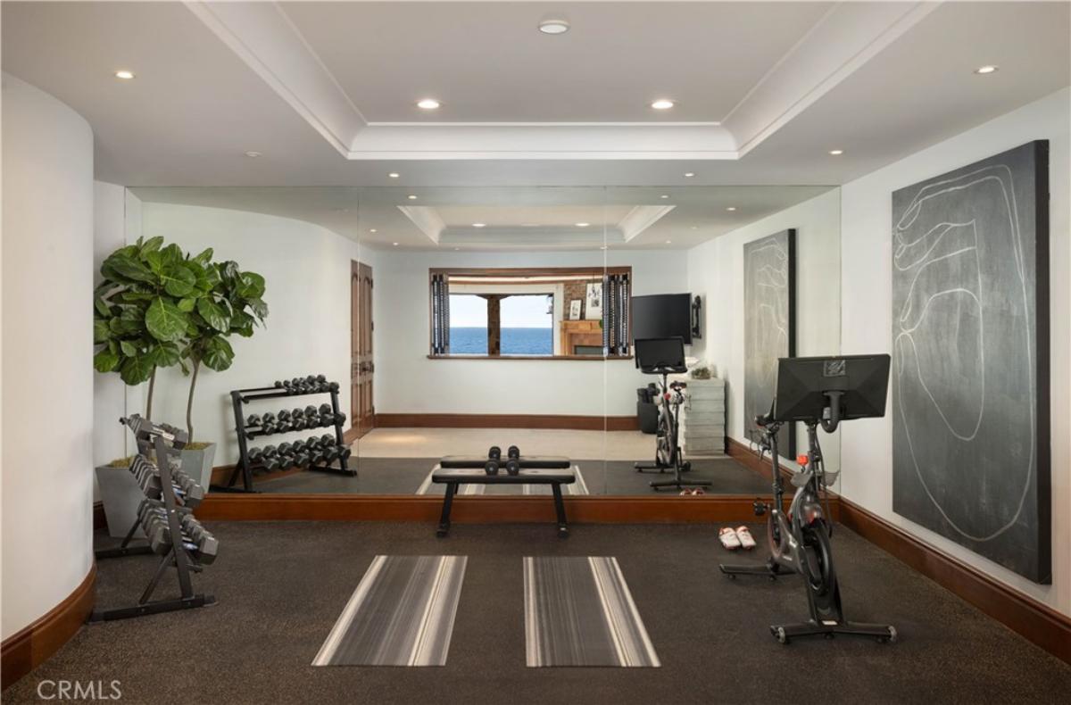 Home gym with workout equipment and custom lights.