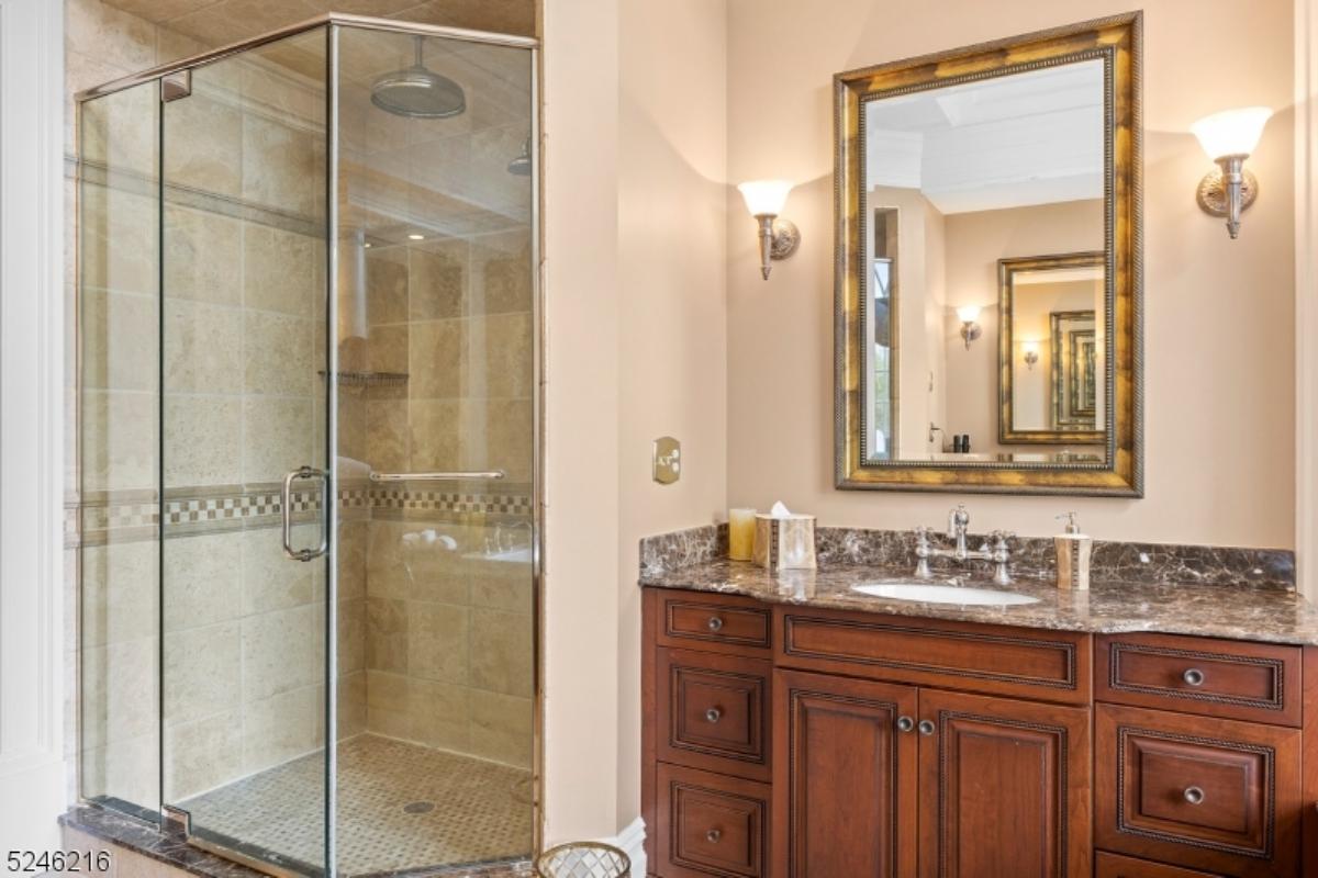 Bathroom with a sink, mirror and a walk-in shower.