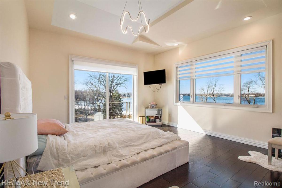 Bedroom with a large bed, glass doors and glass windows.
