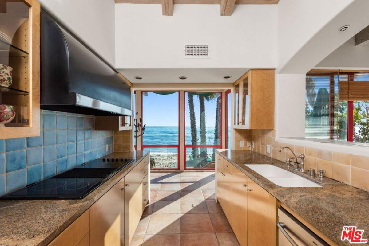 Kitchen with custom blue cabinet, stove and a sink.