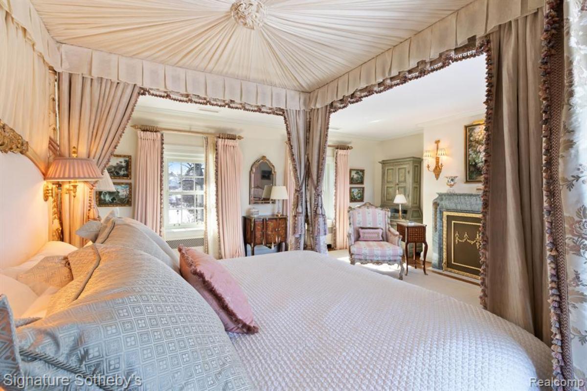 Bedroom with a large bed, chair and a glass window.