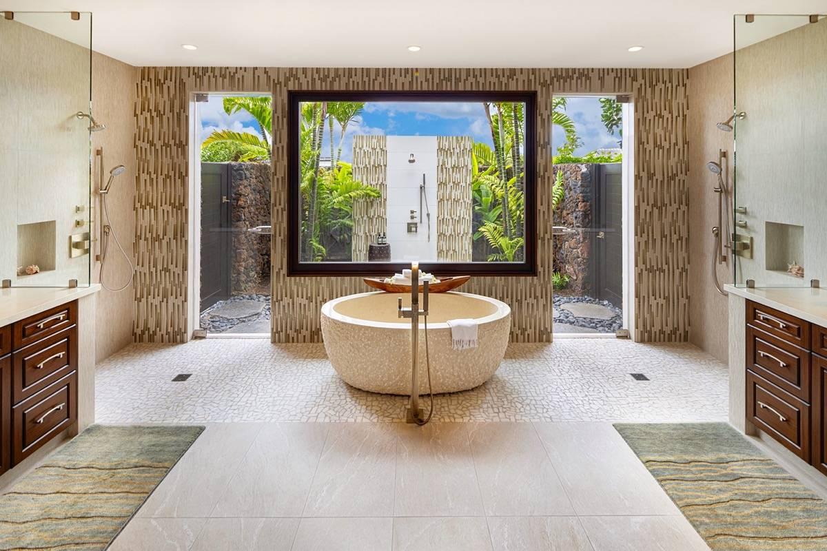 Bathroom with a soaking tub, shower and a glass window.