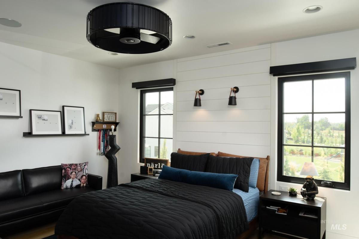 Bedroom with a large bed, couch and glass windows.