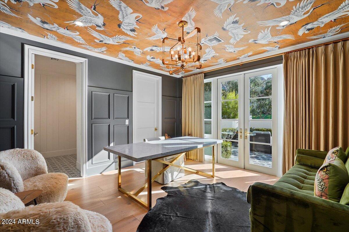 Home office with a desk, couch and glass doors.