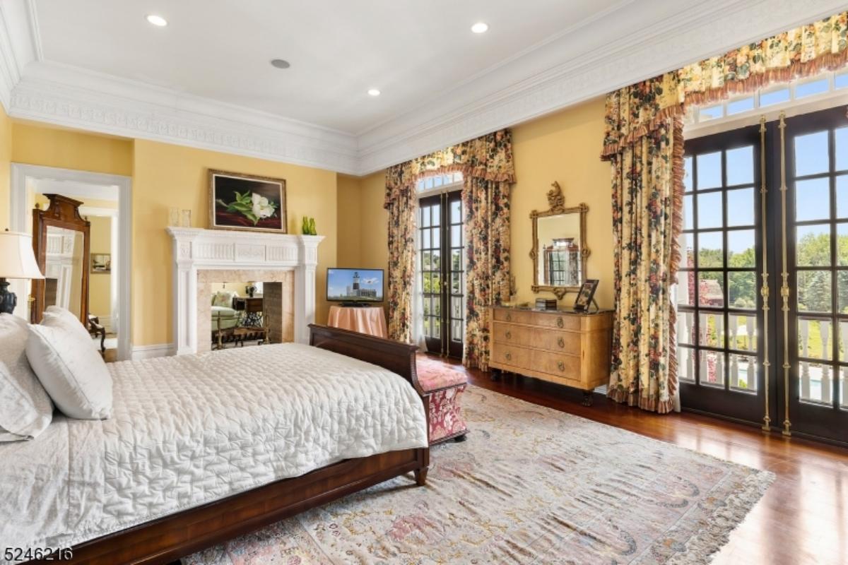 Bedroom with a large bed, custom lights, glass doors and a large rug.