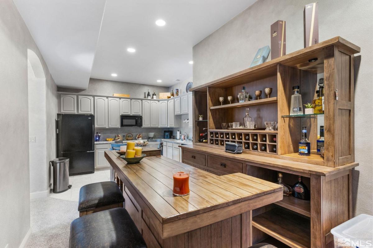 Kitchen with a black refrigerator, custom lights and custom cabinets.