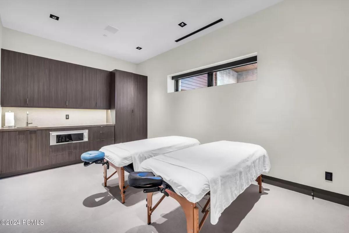 Massage room with two beds, carpet flooring ang custom lights.