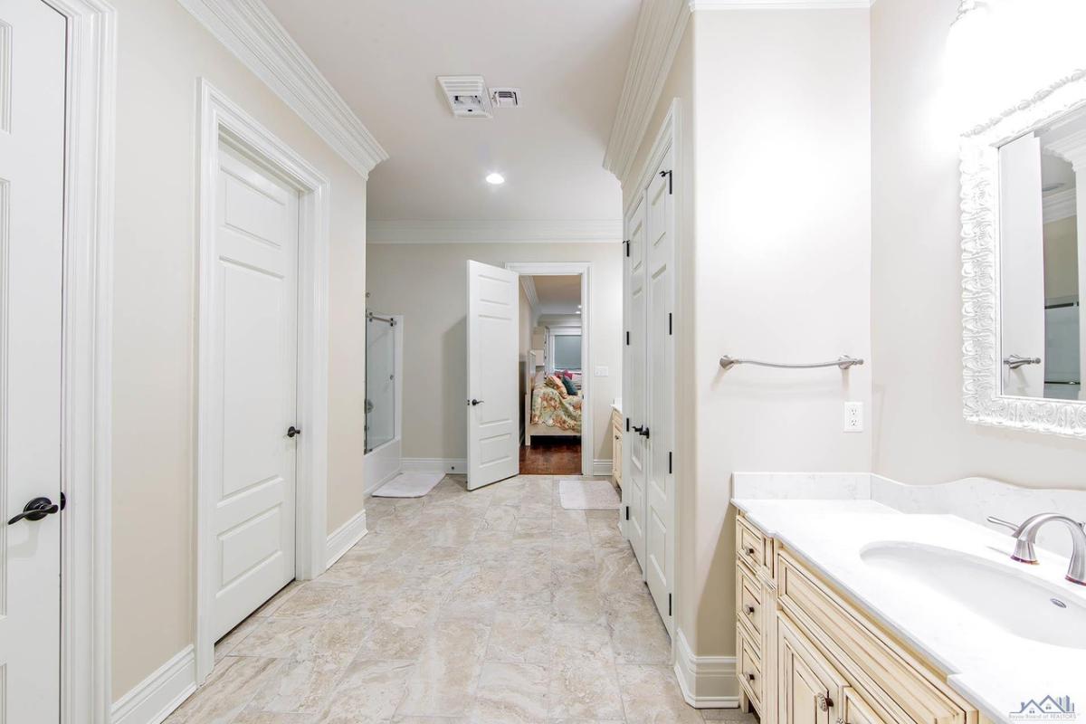 Bathroom with a sink, mirror and glass doors.