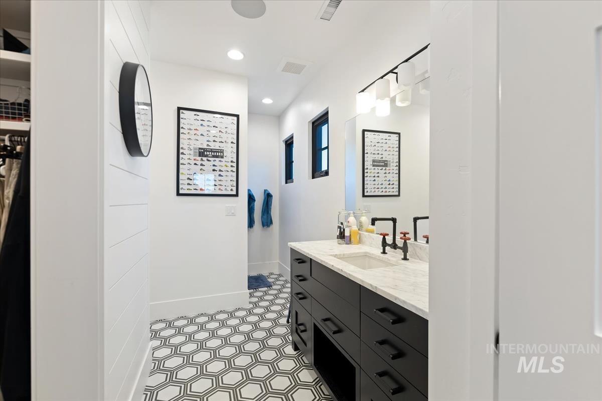 Bathroom with a sink, mirror and custom lights.