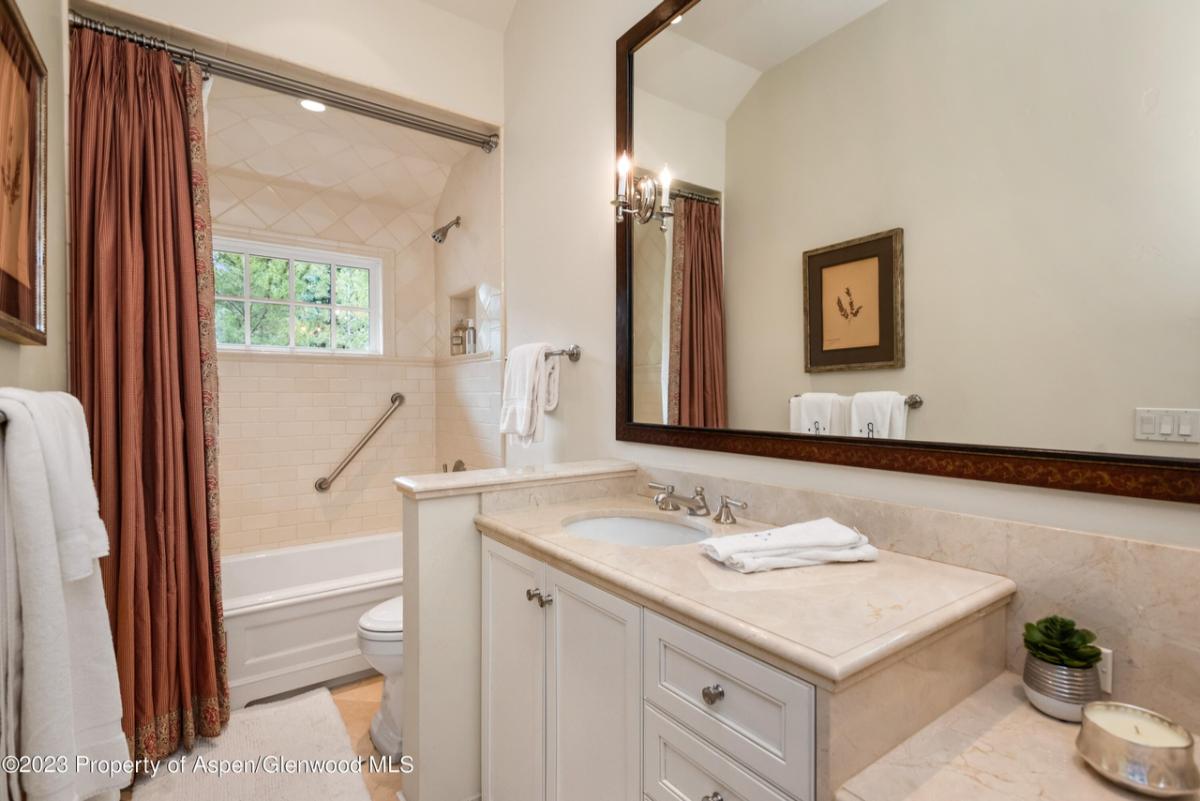 Bathroom with a toilet, fireplace, sink, shower and soaking tub.