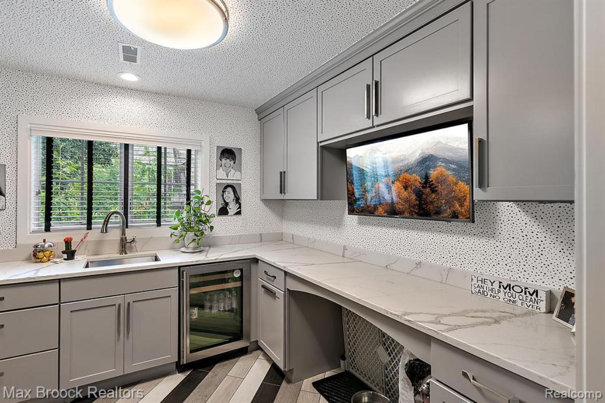 Kitchen with a sink , custom cabinets and marble counter tops.