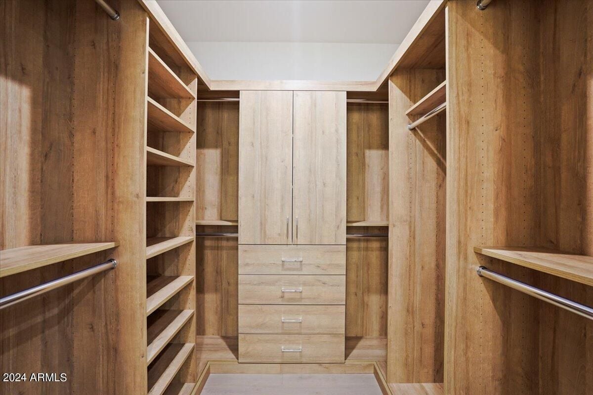 A walk-in closet with wooden cabinets.