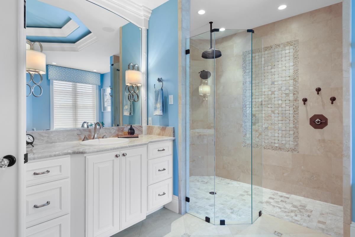 Bathroom with sink, mirror, custom lights and walk-in shower.
