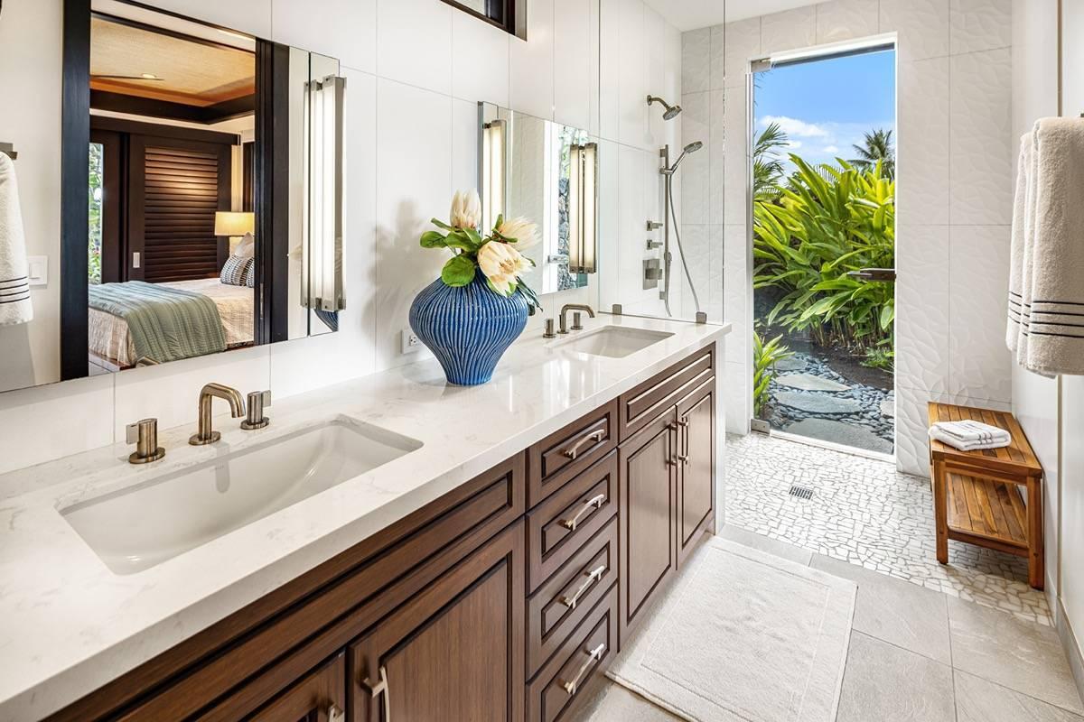 Bathroom with dual sinks, mirror and shower.